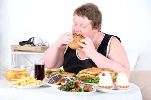 En mand spiser junkfood og illustrerer forskellene mellem sult og angst