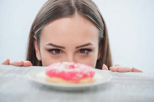 En kvinde kigger på en donut