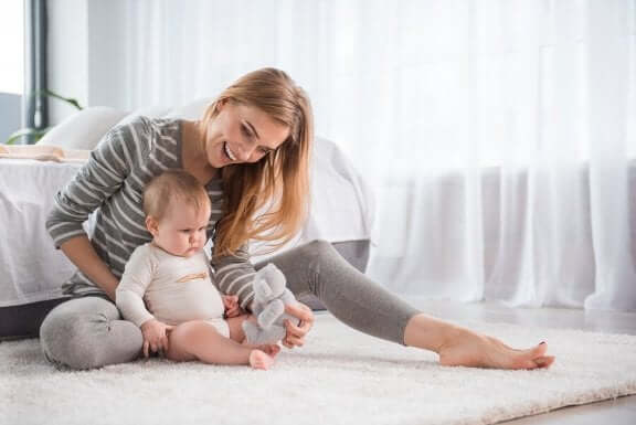 Moderen er i gang med at lære baby at sidde