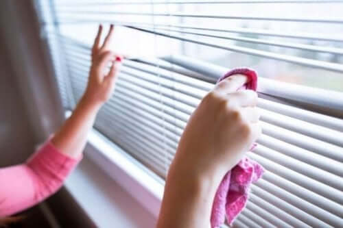 Kvinde i færd med at rengøre persienner