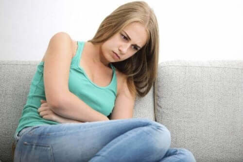 Kvinde, der tager sig til underliv, bemærker effekten af fortrydelsespillen