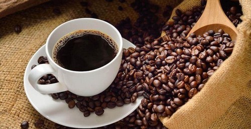 Kaffekop omgivet af kaffebønner 