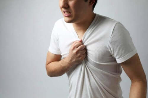 En mand tager sig til brystet