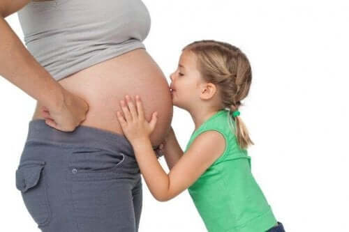 Pige kysser mors gravide mave