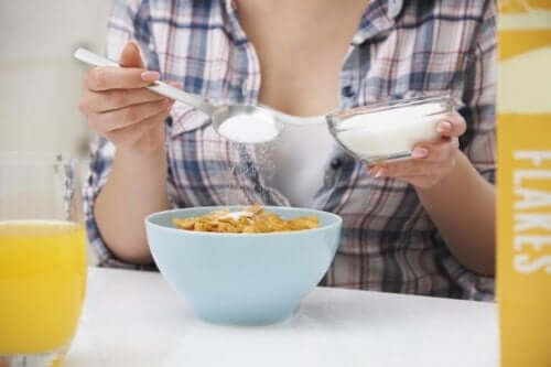 Kvinde kommer sukker på cornflakes