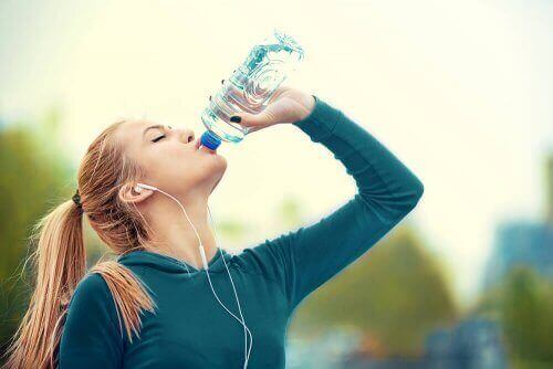 Kvinde drikker vand for at undgå hovedpine om sommeren