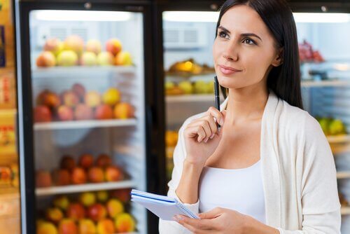 Kvinde ved køleskabe fyldt med frugt