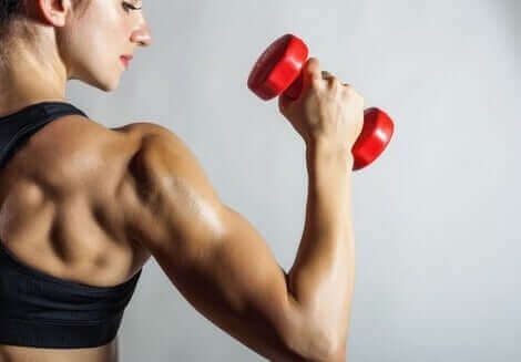 Kvinde med håndvægt forsøger at undgå biceps tendinitis