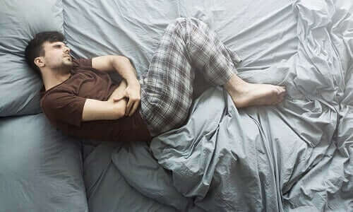 Mand i seng har smerter i maven og ønsker at nyde de forskellige fordele ved ricinusolie