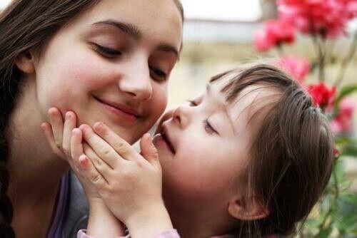Barn med Downs syndrom kysser sin mor 