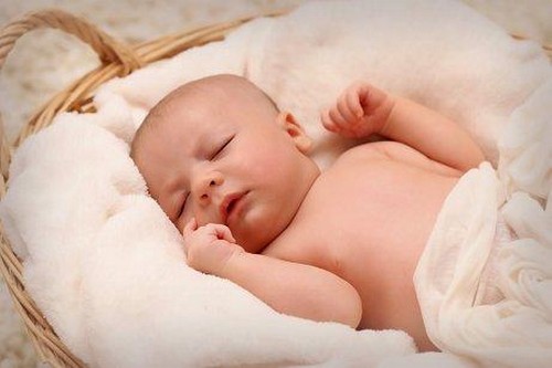 Baby sover fredfyldt i en kurv