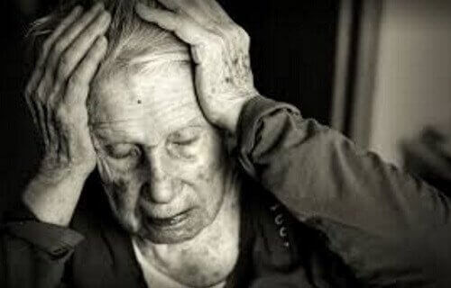 Ældre kvinde, der tager sig til hoved, oplever effekten af mangel på cholin i forebyggelse og behandling af kognitiv sygdom som Alzheimers