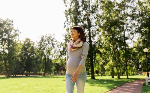 Gravid kvinde går tur som eksempel på motion under graviditet
