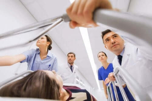 Kvinde i seng køres af læger