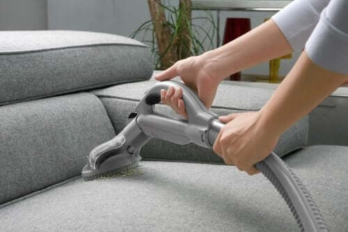 Kvinde støvsuger sofa