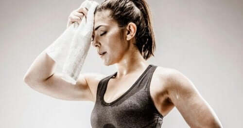 Kvinde i træningstøj tørrer sin pande