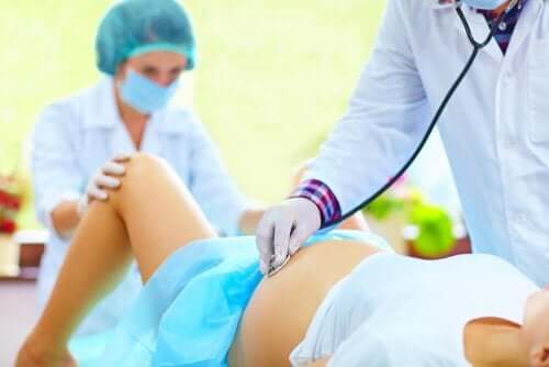 Fødende kvinde tjekkes af læge