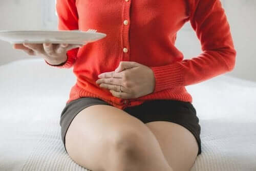 Kvinde med mavesmerter tager sig til mave