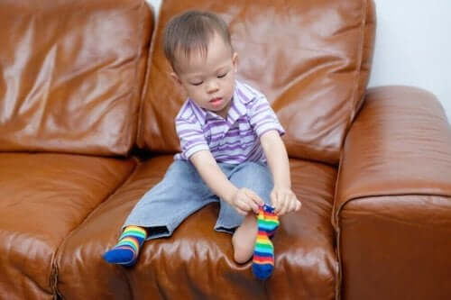 Udvikling af motorisk færdighed: Et barn, der tager sokker på