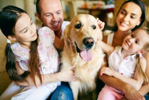 Familie sidder med en hund