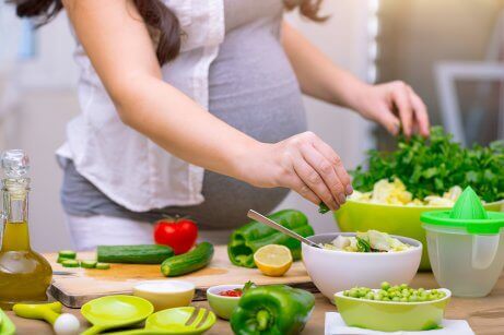Gravid kvinde laver salat