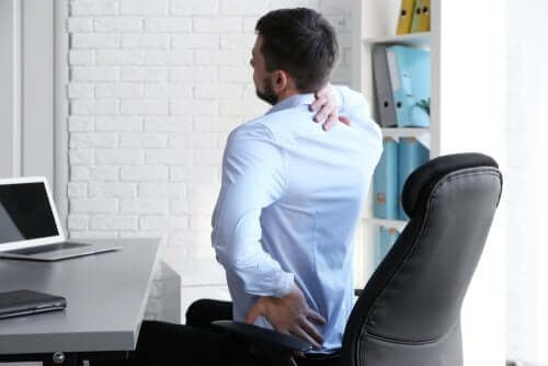 Mand strækker ud på kontorstol for at behandle lændesmerter