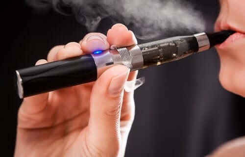 Kvinde damper på en e-cigaret