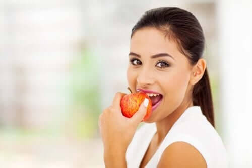 Kvinde spiser et æble, der indeholder pektin 