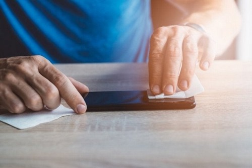 Person desinficerer sin mobiltelefon