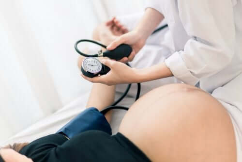 Læge tjekker gravid kvindes blodtryk