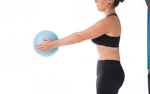 Kvinde med bold dyrker pilates under graviditet