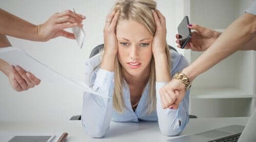 Kvinde med stress på kontor, hvor alle peger fingre