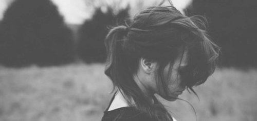 Sort/hvid billede af nedtrykt kvinde , der har problemer med at tilgive sig selv