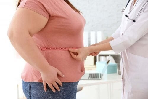 Overvægtig person bliver målt hos lægen 