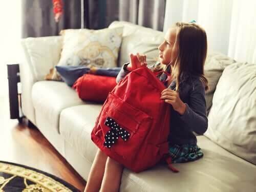 Der er et forhold mellem skoletasker og rygsmerter, som illustreres af pige, der sidder med skoletaske