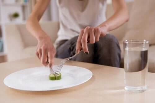 Kvinde, der spiser agurk, oplever spiseforstyrrelser som et advarselstegn på psykisk sygdom