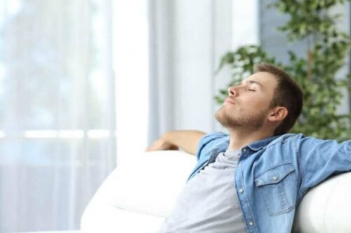 Afslappet mand i sofa anvender afslapningsteknikker