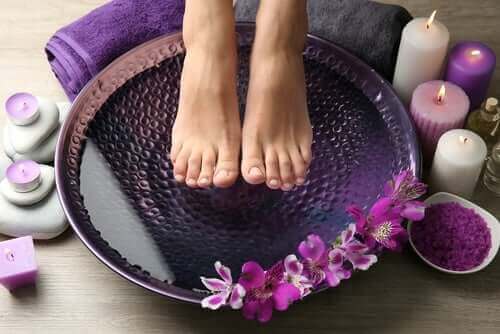 Fodbad med lilla blomster og lys