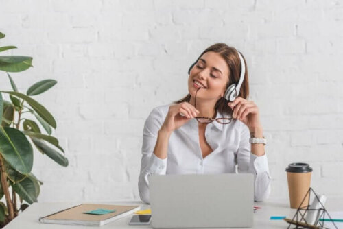Kvinde smiler ved skrivebord med computer