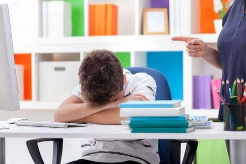Søvnforstyrrelser hos børn illustreres af træt dreng, der hviler hoved på arme