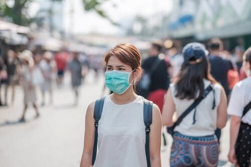 Kvinde bærer maske i offentligheden