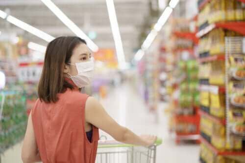 Kvinde handler i supermarked med mundbind på