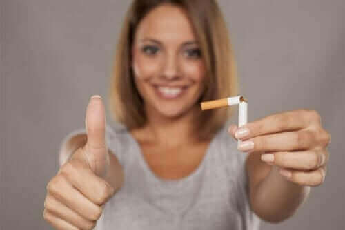 En kvinde, der viser en knækket cigaret