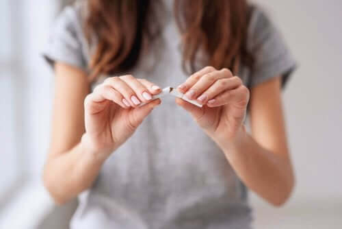 Kvinde knækker cigaret som symbol for rygestop