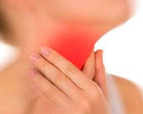 Kvinde tager sig til rød hals som illustration af at passe på stemmen