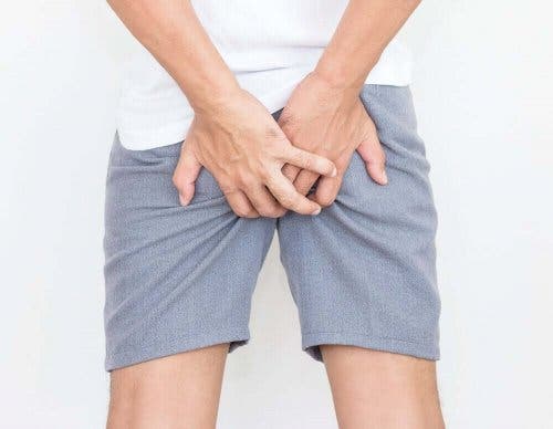 Blod i afføringen kan være smertefuldt, hvilket illustreres af mand, der tager sig til bagdel