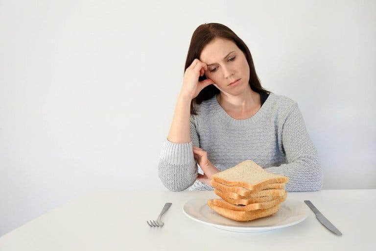 Kvinde ser trist på hvidt brød