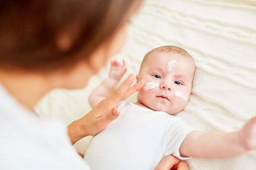 En baby får creme på