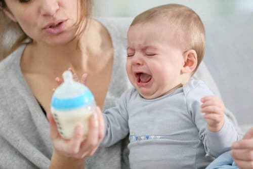 Baby med mælk foran sig græder som følge af mavetarminfektion hos babyer