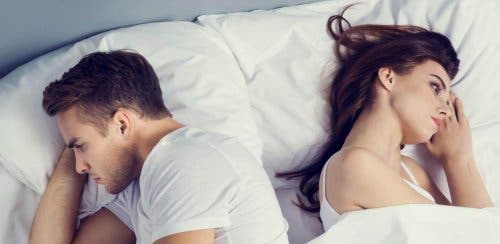 Frustreret par i seng kigger væk fra hinanden